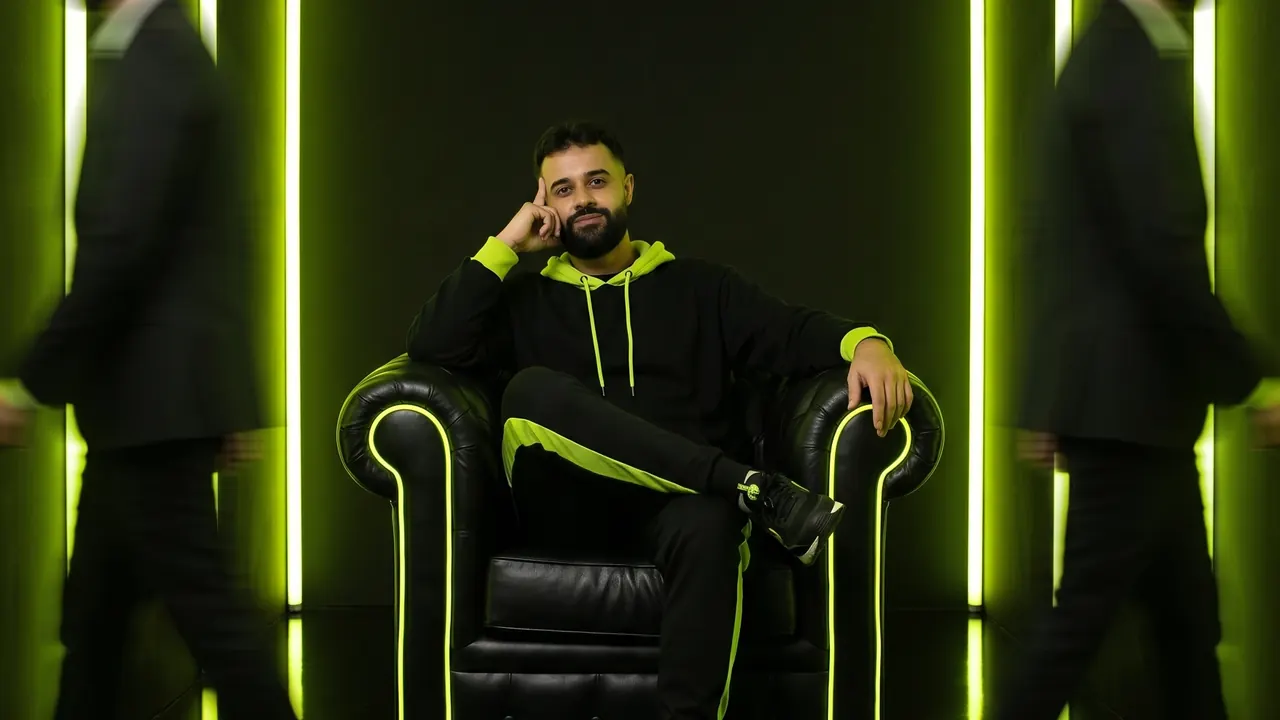 Israel Meira sentado numa poltrona com contorno de neon lime, entre colunas de luz lime